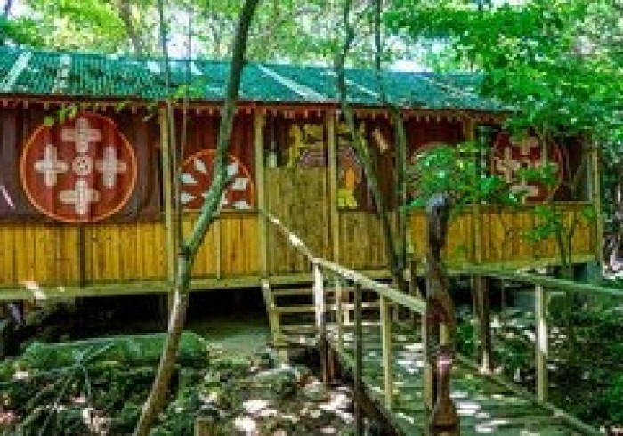 Spacious hut suite at Great Huts eco resort in Portland Jamaica with sitting area and art pieces